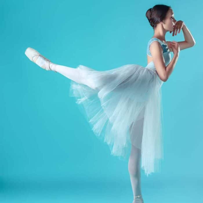 ballerina in white dress posing on toes studio PA9XMNQ